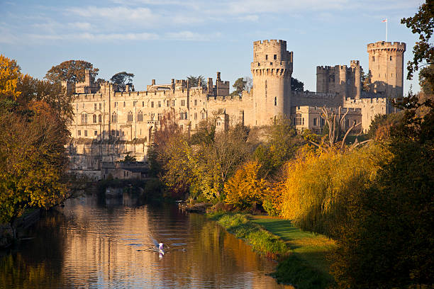 Warwick Castle A rower sculls along the River Avon overlooked by Warwick Castle warwick uk stock pictures, royalty-free photos & images
