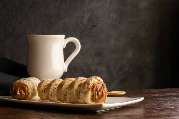 Composition of Argentine snack with cannon of dulce de leche and cup with infusion.