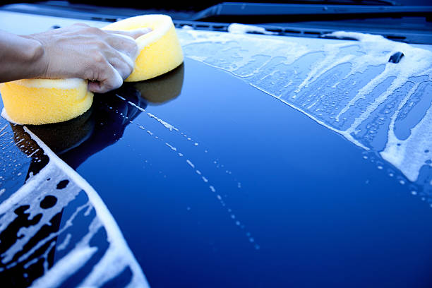 Female cleaning her car with car cleaning rag, cloth