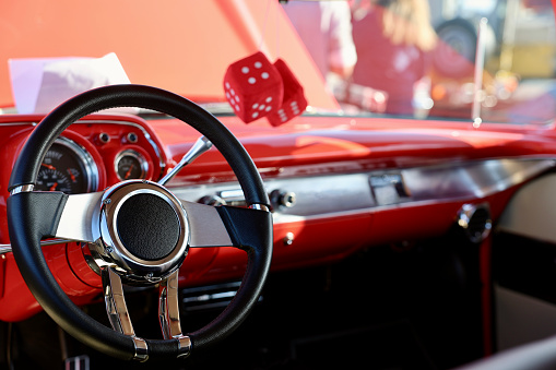 Fuzzy red dice hanging from the sports car mirror