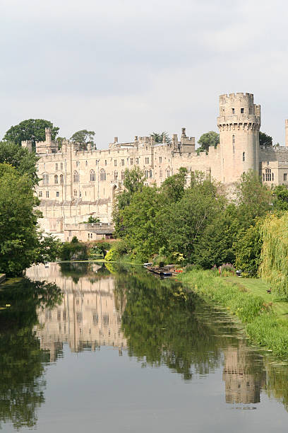 Warwick Castle Warwick Castle reflected in the still waters of the Rive Avon. warwick uk stock pictures, royalty-free photos & images