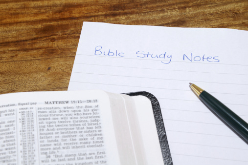 A bible with study notes and a ballpoint pen.