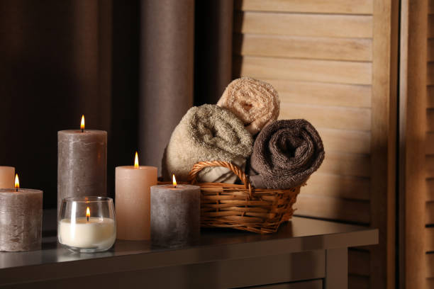 istock Spa composition with burning candles and rolled towels on table in wellness center 1771350345