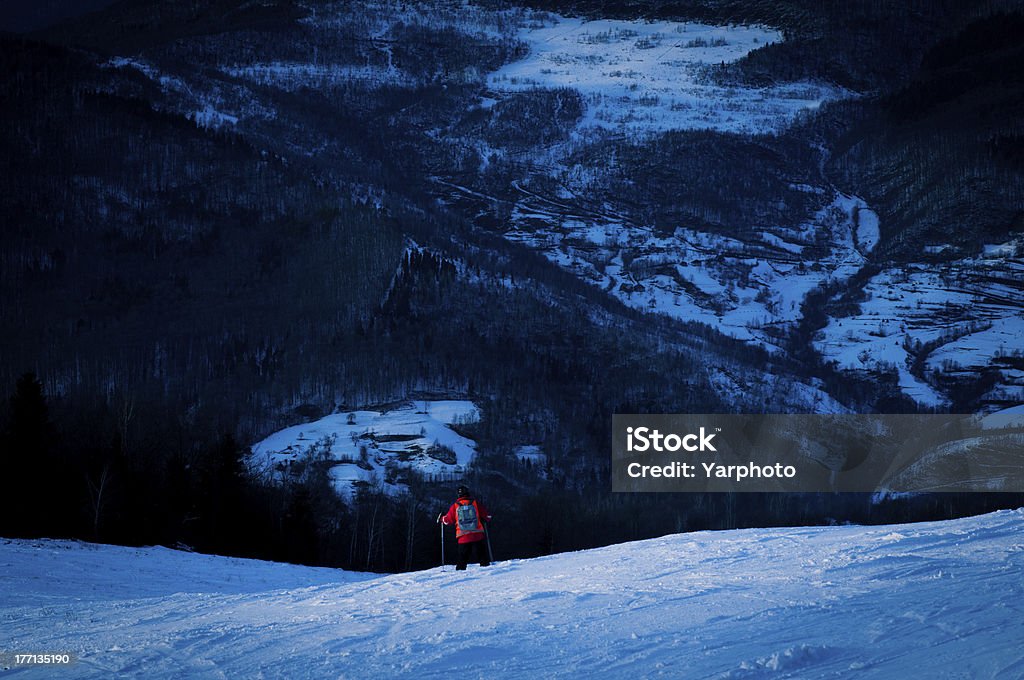 in the mountains at dusk rescuer.  on the slope of the ski trails at dusk Activity Stock Photo