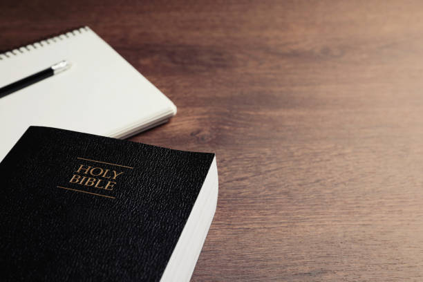 istock Holy Bible and notebook with pencil on wooden table, closeup. Space for text. Religious book 1771352603