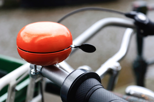 Bright orange bicycle bell. Shot was taken in Amsterdam, Holland.
