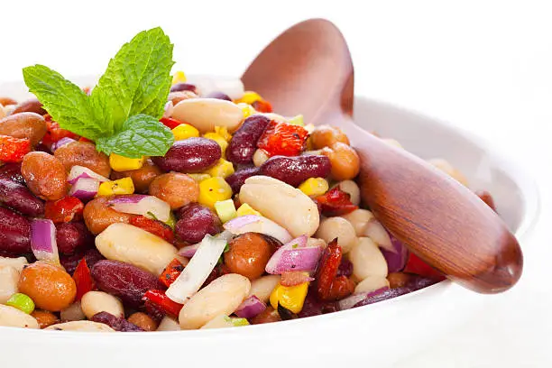 "Three bean salad with sweetcorn, roasted red peppers and red onion in a vinaigrette dresing."
