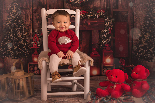 A child on a Christmas stage sitting on a chair