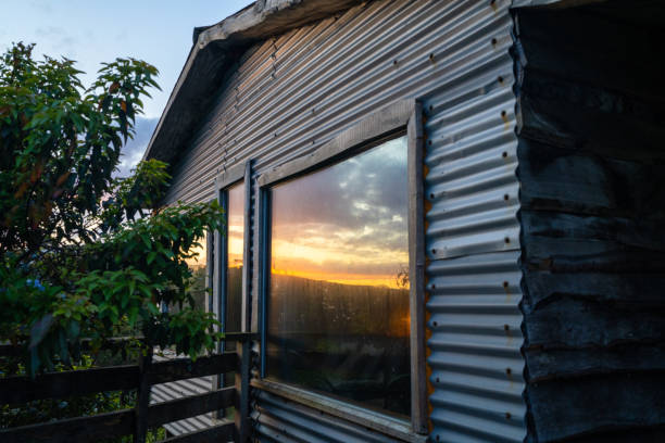 The Sunset Reflection off of a Vacation Cabin That Has A Large Bay Window