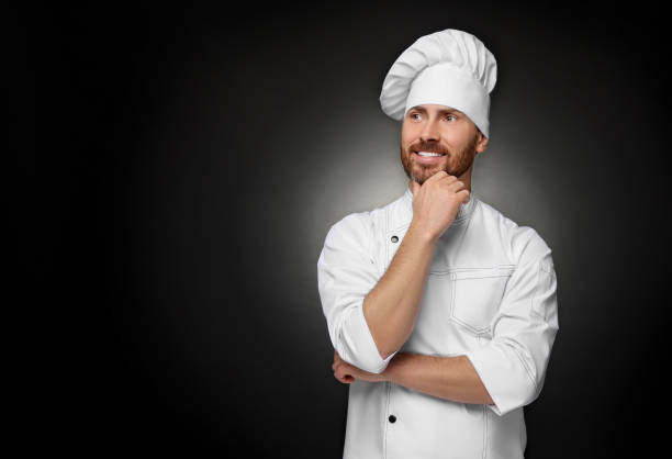 istock Smiling mature chef on black background, space for text 1771390087