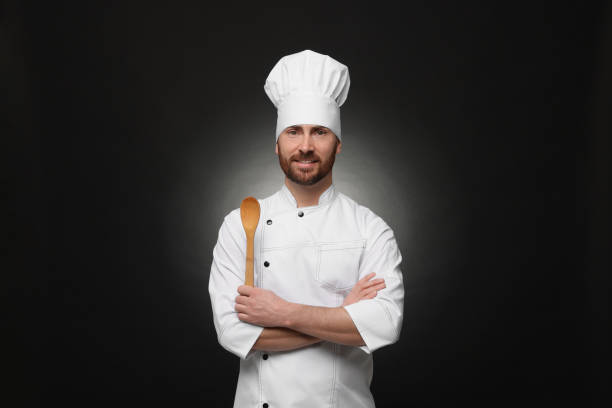 istock Mature chef with spoon on black background 1771390645