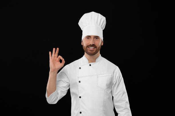 istock Smiling mature chef showing ok gesture on black background 1771390875