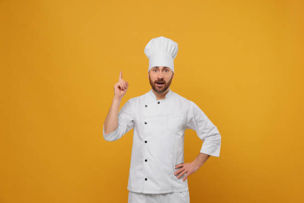 istock Mature male chef showing idea gesture on orange background 1771391819