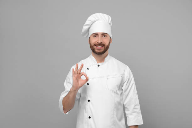 istock Smiling mature chef showing ok gesture on grey background 1771391829