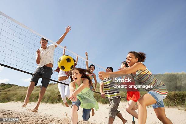 Group Of Friends Playing Volleyball On The Beach Stock Photo - Download Image Now - Beach, Teenager, Volleyball - Sport