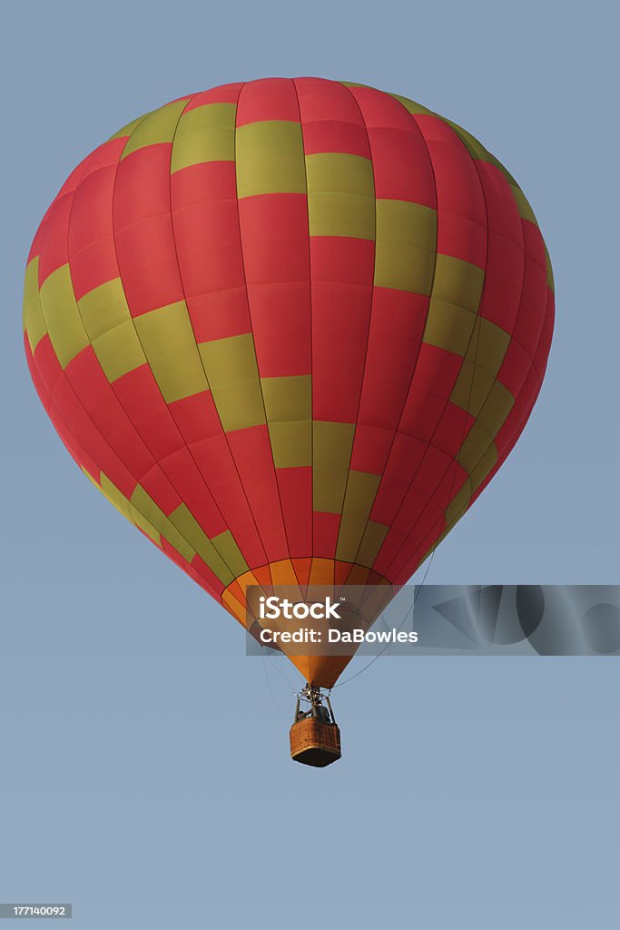 Balmy Ballooning "A colourful hot air balloon drifting through a blue sky, with small basket, pilot and crew" Basket Stock Photo