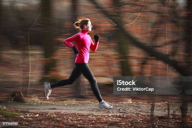 Running Woman In Focus With Blurred Woodland Background Stock Photo - Download Image Now