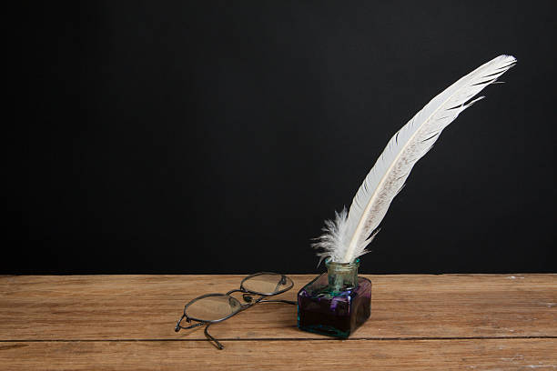 istock Quill and inkwell, vintage spectacles on wooden table 177140418