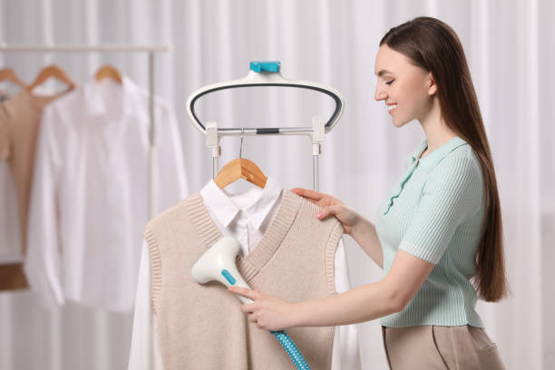 istock Woman steaming clothes on hanger at home 1771406476