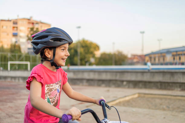 A little girl drives a bicycle carefully.