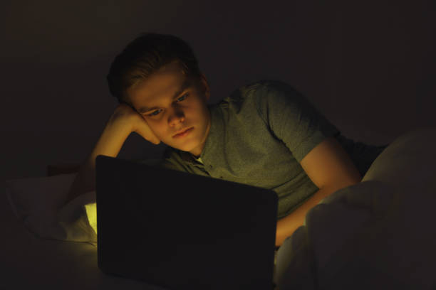 istock Teenage boy using laptop on bed at night. Internet addiction 1771412423