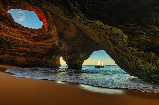 A scenic view of the sea from Benagil in the Algarve, Portugal, Europe with a small sailboat resting in its shallow waters