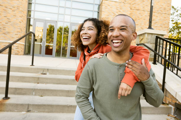 University student couple piggyback in campus