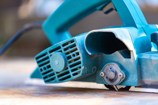 Use an electric planer to polish wood in outdoor under sunshine