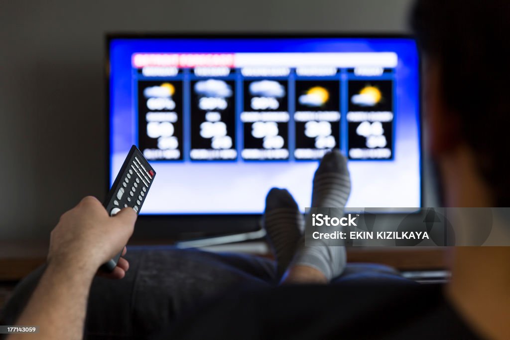 Man watching weather forecast Adult Stock Photo