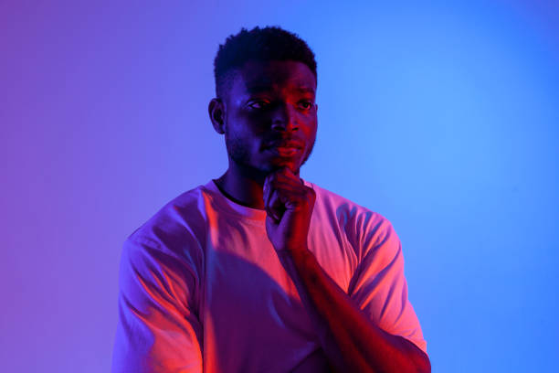 istock pensive african american man thinking and dreaming in neon lighting, puzzled guy planning 1771439420