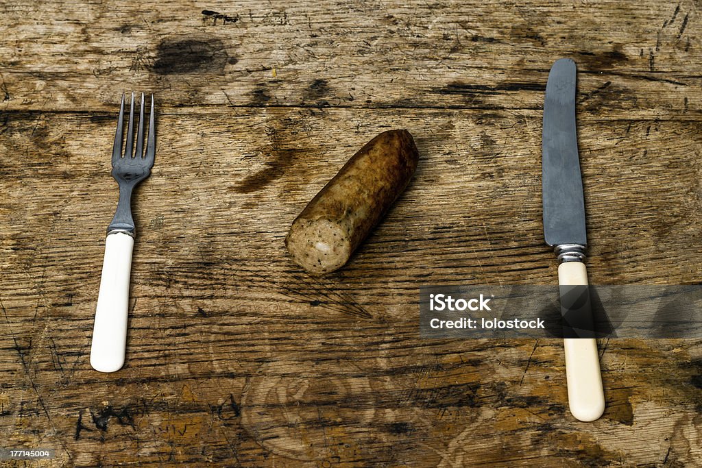 Coltello, forchetta e salsiccia sul tavolo di legno - Foto stock royalty-free di Antico - Vecchio stile