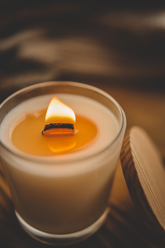 Burning candle in home interior, autumn aesthetics.