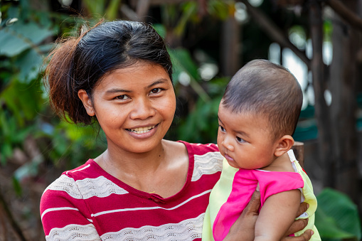 Portrait of mother holding her baby girl near Tonle Sap, Cambodia