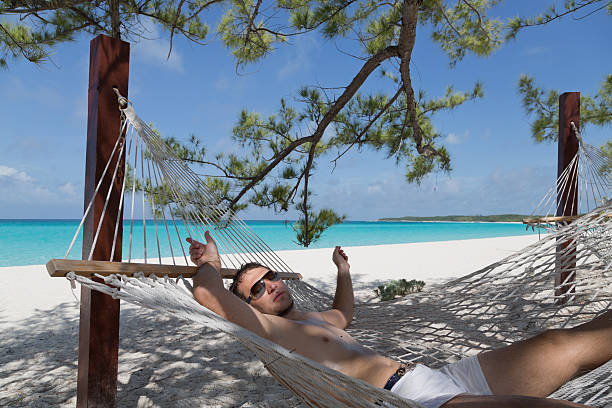 istock Man lying in hammock at the beach 177148202