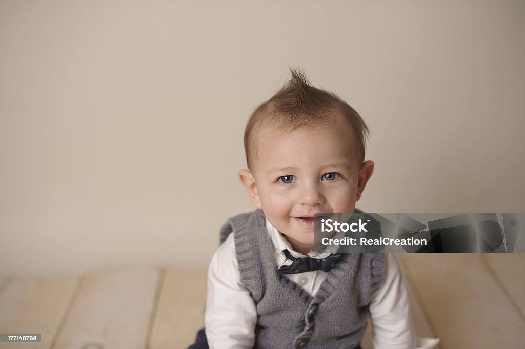 Bambino sorridente seduto sul pavimento in legno - Foto stock royalty-free di Bambini maschi