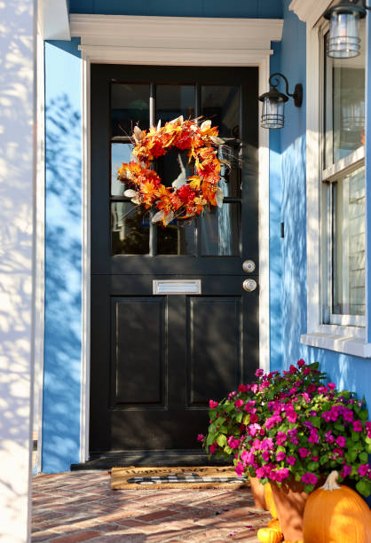 istock Blue cottage with black front door and autumn decor 1771499909