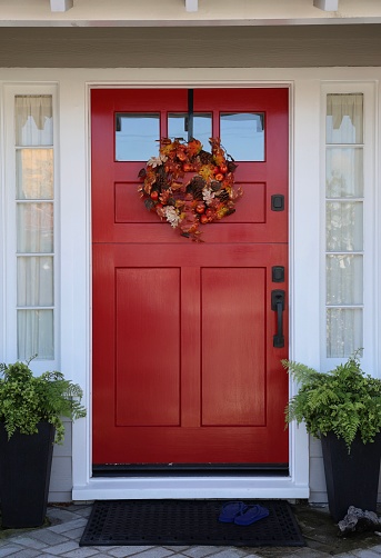 Bright red front door with autumn leaves wreath