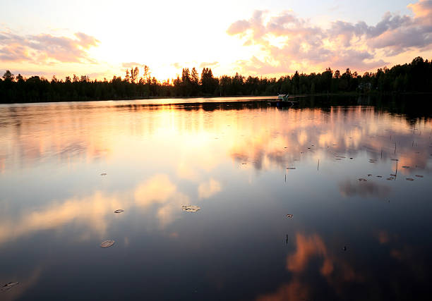istock purple sunset and a cloudy sky mirrored on lake surface 177152866