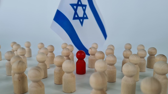 Group of people figurines and small flags of Israel. Red special man to the crowd traitor