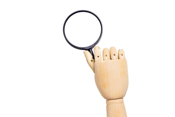 istock wooden hand holding a magnifying glass isolated on white background 1771583821