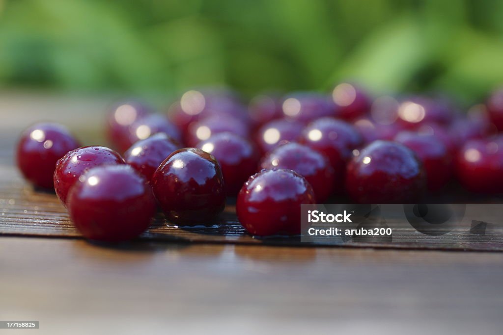 Cherries Fruit Summer Still Life. wet cherry on a wooden plank on a green blurred background Alcohol - Drink Stock Photo