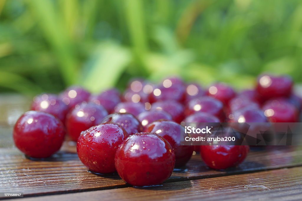 Cherries Fruit Food Summer Still Life. wet cherry on a wooden plank on a green blurred background Alcohol - Drink Stock Photo