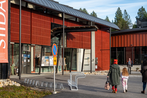 Inari, Finland Oct 7, 2023 A woman and child walking to the  main entrance to the Siida Museum, or Museum of the Sami people.