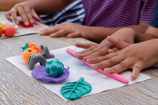 Plasticines' Molding Children with learning disabilities are practicing plasticine shapes such as animals and fruits on the table with friends. Idea for learning by doing for children with learning disabilities. clay sculpture stock pictures, royalty-free photos & images