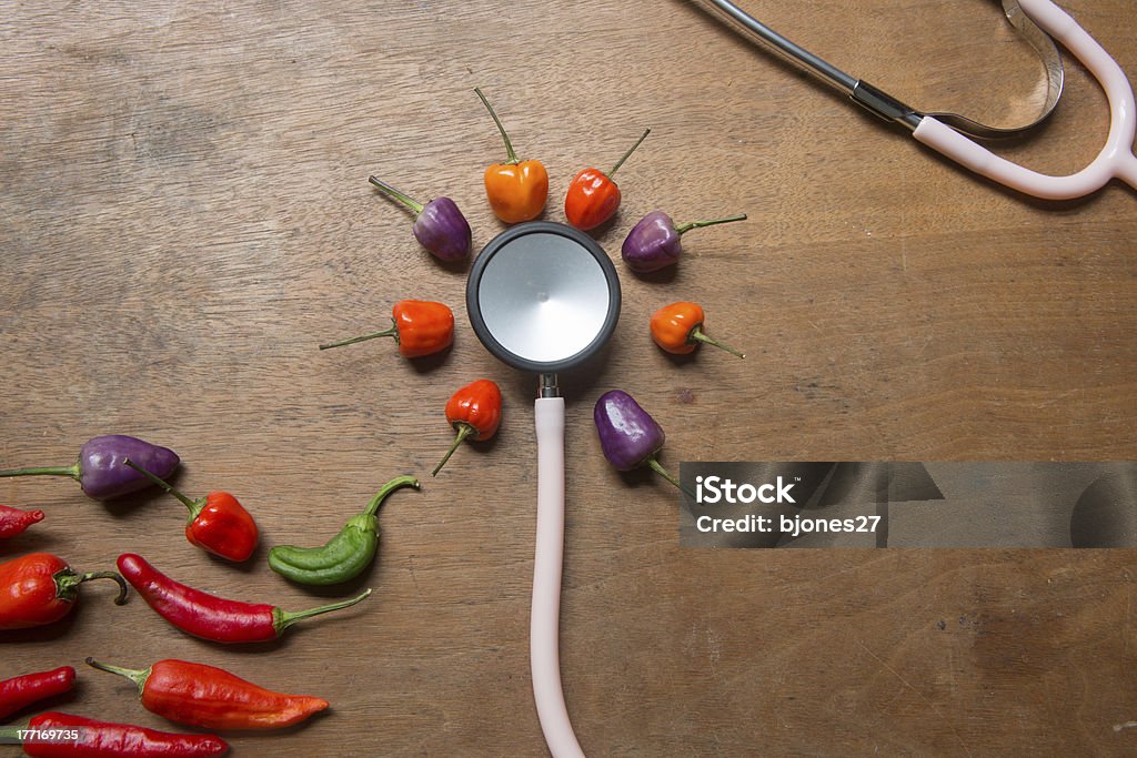 Pimientos con opciones frías y calientes y un estetoscopio - Foto de stock de Alimento libre de derechos