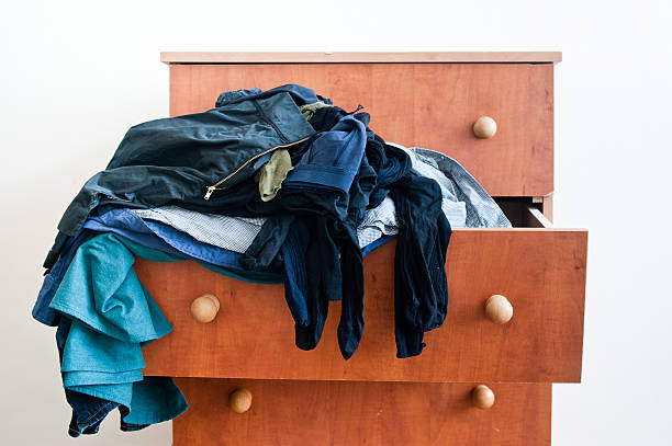 Messy chest of drawers with clothes stock photo