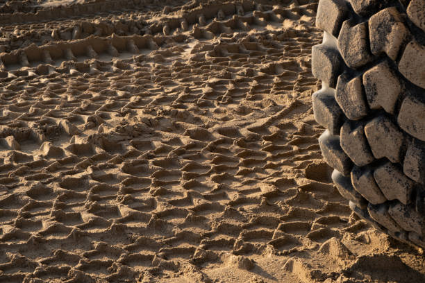 construction site, the distinctive imprint of a tractor wheel is left on the sandy ground, showcasing the heavy machinery's impact