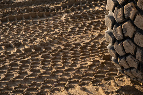 plac budowy, na piaszczystym podłożu pozostawiono charakterystyczny odcisk koła ciągnika, ukazujący uderzenie ciężkiego sprzętu - tire track making tire construction zdjęcia i obrazy z banku zdjęć