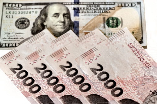 Argentine banknotes of 2000 pesos and american one hundred dollar bill.