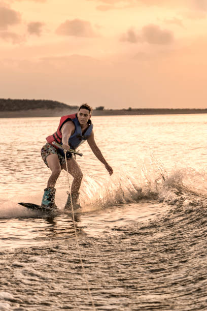 istock Young adult practicing wakeboarding, on lake at sunset. 1771798752